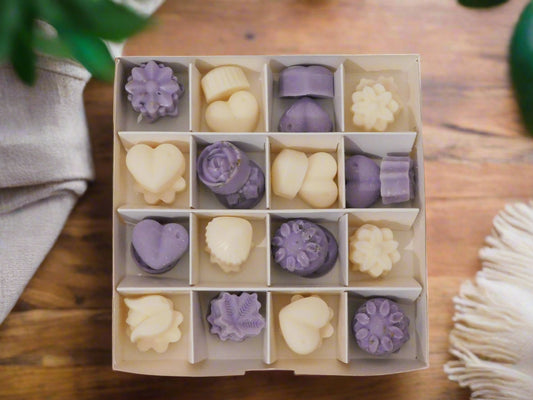 A box of handmade soya wax melts with a Jasmine and Lavender collection. The box is opened, showing multiple pieces of wax melts in shades of purple and white.