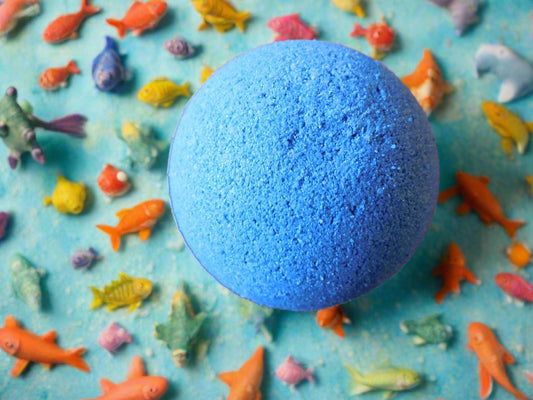 deep sea blue rounded bath bomb with colourful fishes all around the bath bomb