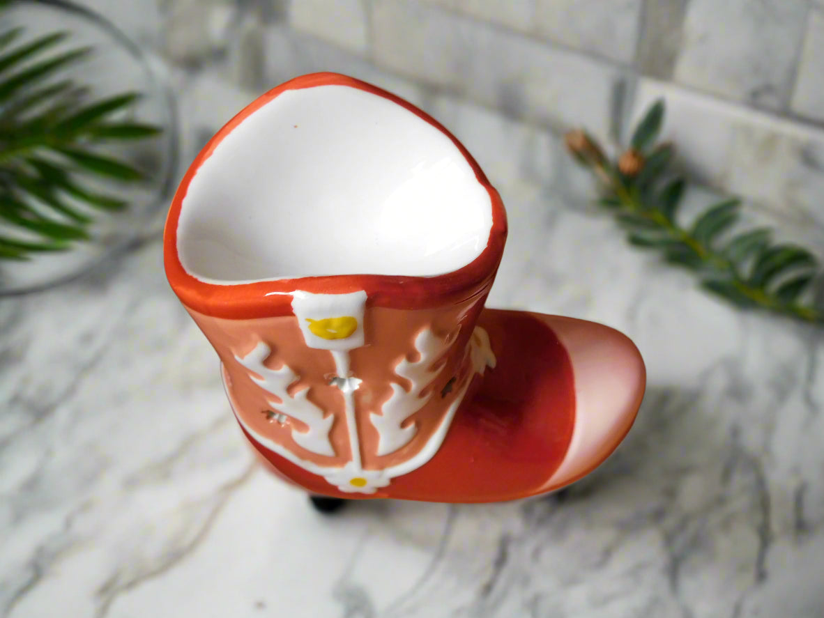 A ceramic cowboy boot oil burner and wax warmer in red and white color, view from the top